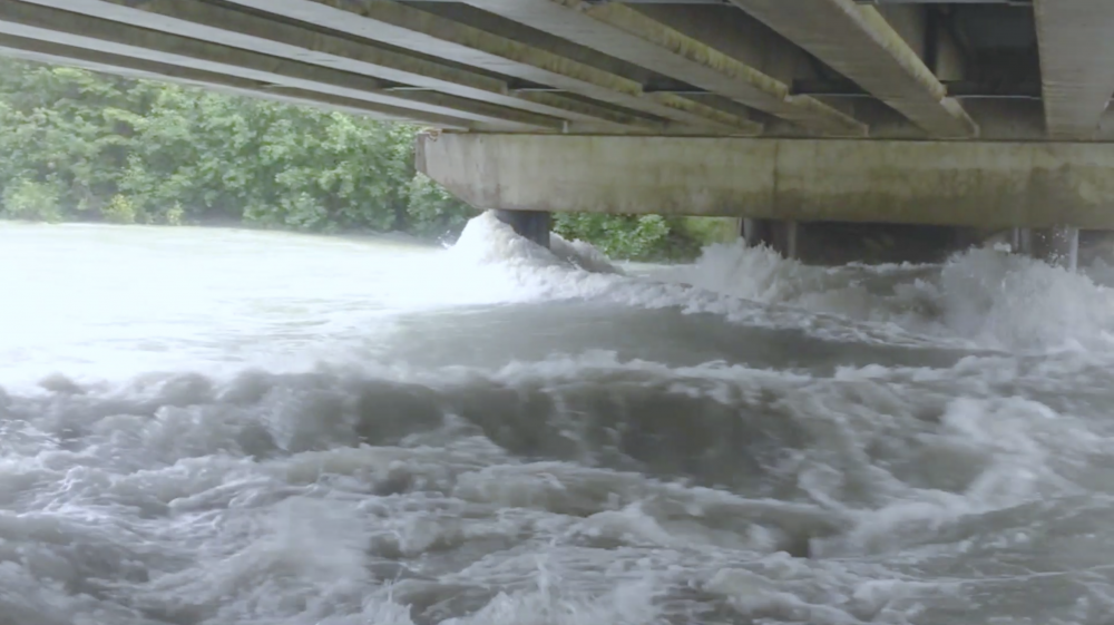 Water rushes under a Juneau bridge during a flood.